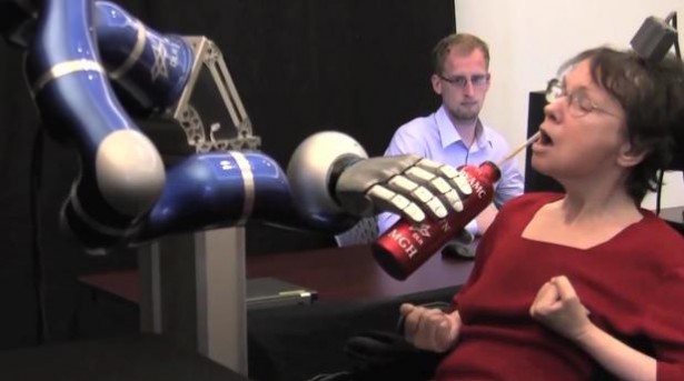 Verlamde vrouw drinkt koffie met robot-arm