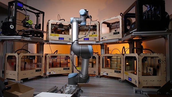 Deze robot zet een flinke groep 3D-printers aan het werk